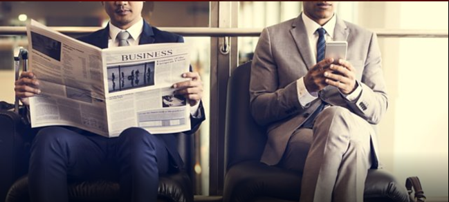 Two men reading newspapers