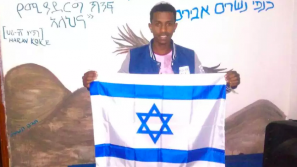 Ethiopian Jew Sintayehu Shifaraw holding up an Israeli flag
