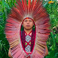 An indigenous man wearing a feather headdress