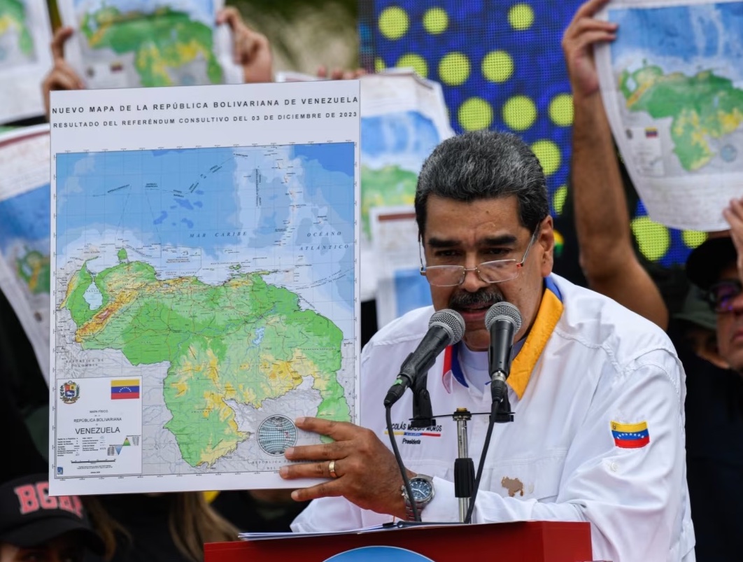 President Maduro of Venezuela holding up a map showing Venezuela's claim on Guyana's Essequibo region.