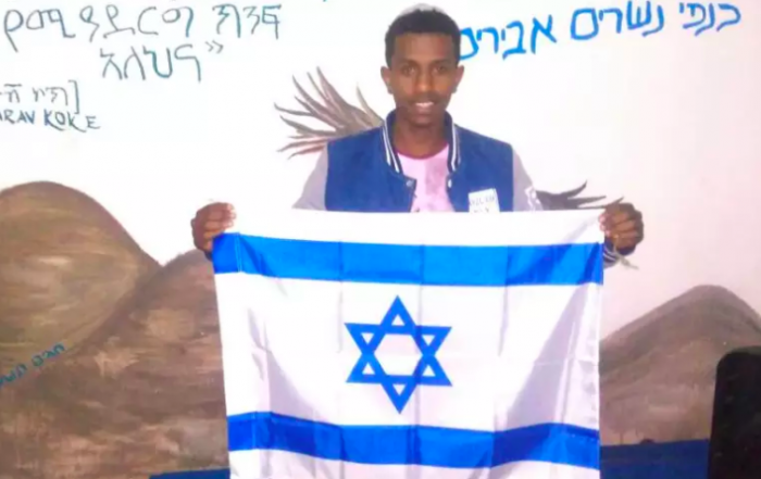 Ethiopian Jew Sintayehu Shifaraw holding up an Israeli flag